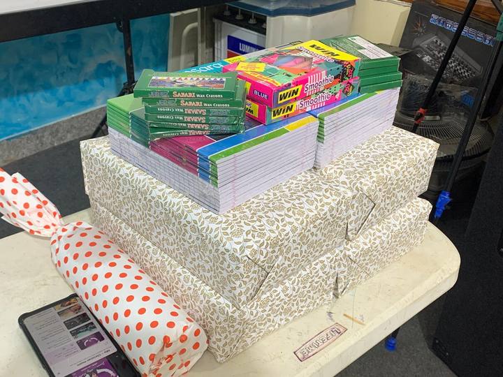Wrapped parcels, notebooks and boxes of crayons stacked on a table